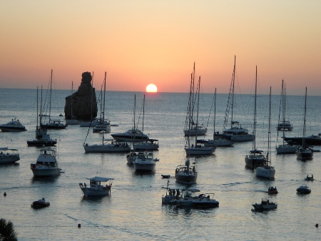 Islote de Es Cap Bernat rodeado de barcos al anochecer