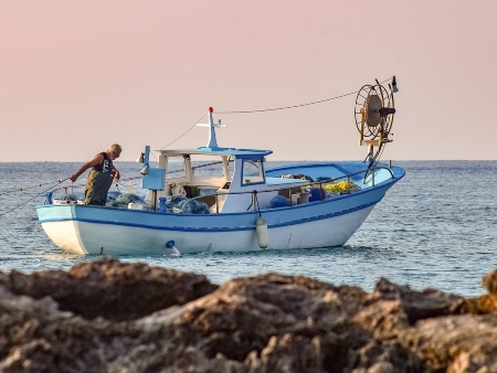 La Pesca en Ibiza: Pescador en su barco frente a la costa